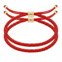 Braided string jewelry featuring two vibrant red bracelets with gold-toned adjustable sliders and decorative end beads