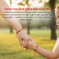 Photograph of a mother and child holding hands in an outdoor park at golden hour, both wearing red string bracelets, the mother with a gold heart charm and the child with a gold star charm on a warm blurred green and gold background