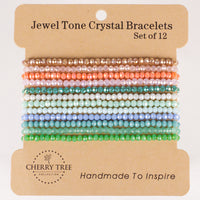 Jewel Tone Crystal Bracelets by Cherry Tree Collection a set of 12 handmade faceted crystal bracelets presented on a brown display card featuring a vibrant color gradient from warm rose gold and peach to cool mint, blue, and various shades of green