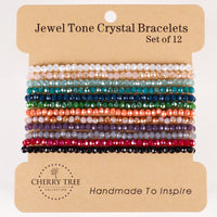 Cherry Tree Collection crystal bead bracelets a set of 12 faceted Jewel Tone Crystal Bracelets in vibrant colors including teal coral orange and deep red displayed on a brown retail card with the Handmade To Inspire slogan
